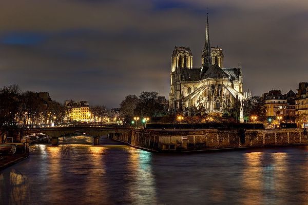 Notre Dame Cathedral and the Seine River shimmer in the Paris-France night